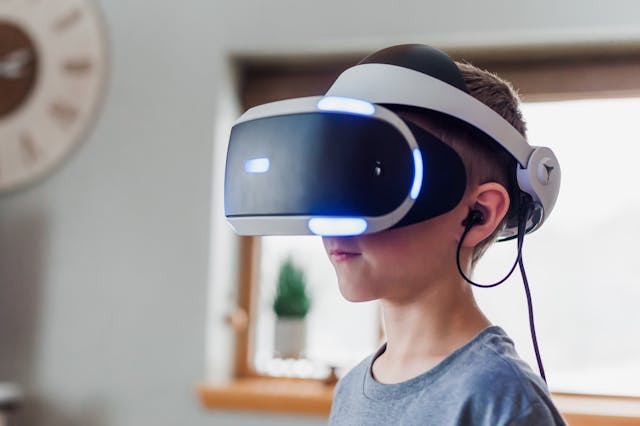 Copil purtând ochelari VR – explorând realitatea virtuală, una dintre tendințele tehnologice din 2024