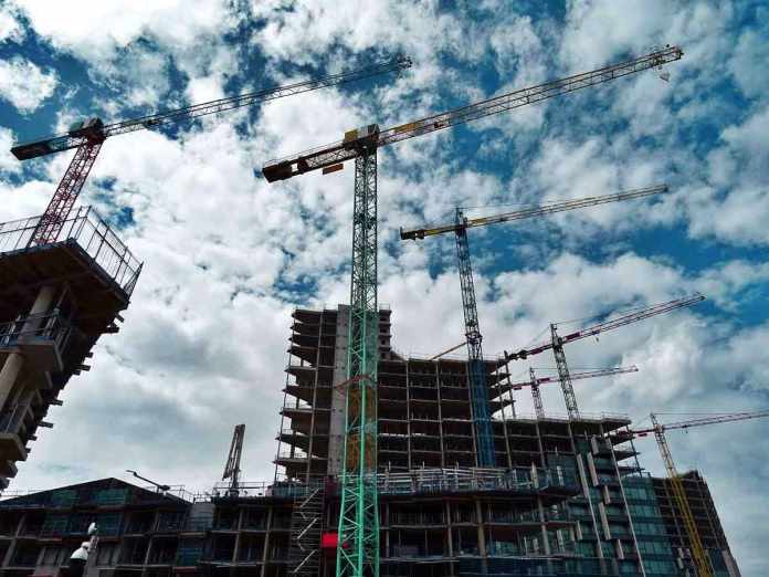 Preturi locuinte 2025: Șantier de construcții cu macarale în acțiune, simbolizând dezvoltarea imobiliară și piața locuințelor în 2025.