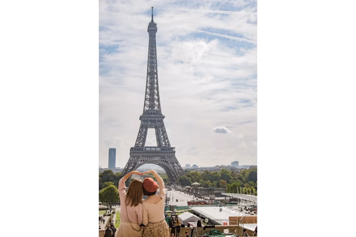 Turiste în fața Turnului Eiffel – călătorii ieftine Europa