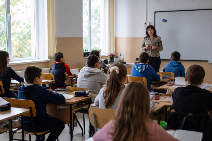 cheltuieli pentru educatie in Romania – elevi si profesor intr-o sala de clasa